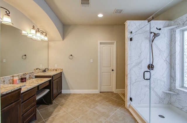 bathroom with a marble finish shower, visible vents, a wealth of natural light, and vanity