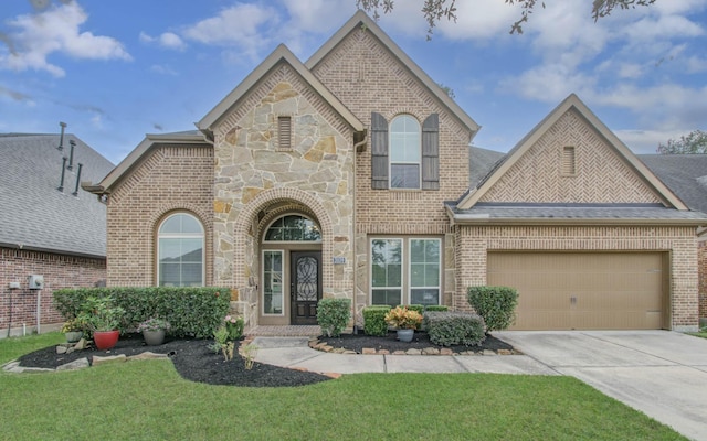 french country style house with a front lawn, brick siding, concrete driveway, and an attached garage