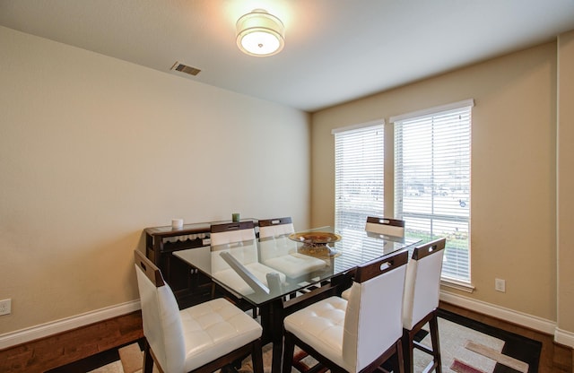 dining space with visible vents, baseboards, and wood finished floors