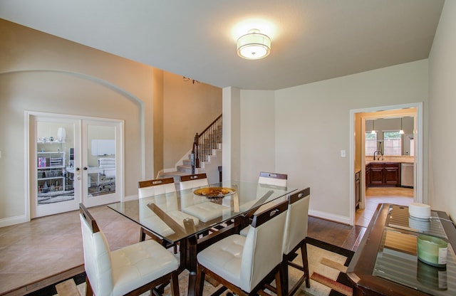 dining room featuring stairs, french doors, and baseboards