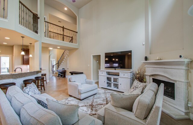 tiled living room with a high ceiling and a fireplace