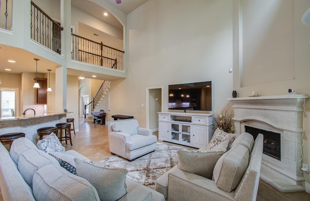 living area featuring a premium fireplace, stairway, and light tile patterned flooring