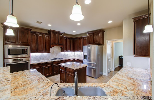 kitchen with visible vents, decorative backsplash, light stone counters, appliances with stainless steel finishes, and a sink