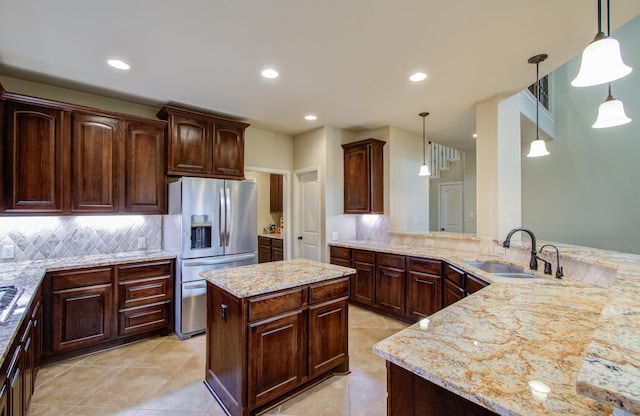 kitchen with sink, hanging light fixtures, dark brown cabinets, stainless steel refrigerator with ice dispenser, and kitchen peninsula