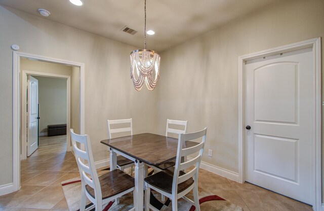 tiled dining room featuring a notable chandelier