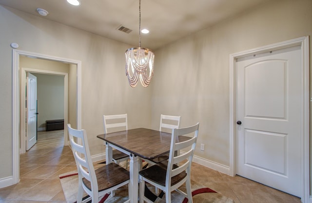 dining area featuring light tile patterned floors, visible vents, baseboards, and an inviting chandelier