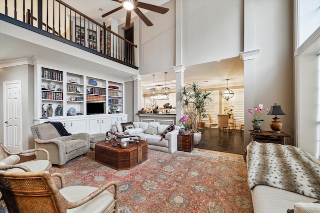 living room with ceiling fan, wood-type flooring, a high ceiling, and ornate columns