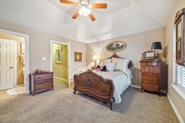 carpeted bedroom with ensuite bath, vaulted ceiling, and ceiling fan