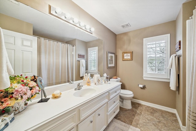 bathroom featuring vanity, toilet, and a wealth of natural light