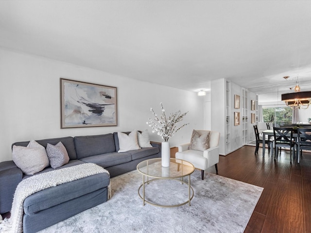 living room featuring dark wood-type flooring and a notable chandelier