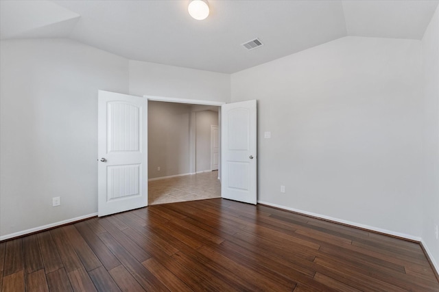 unfurnished room with hardwood / wood-style flooring and vaulted ceiling