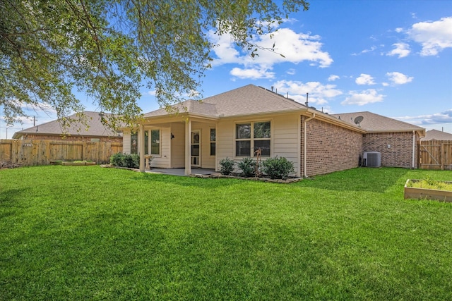 rear view of property featuring a yard, a patio, and central air condition unit