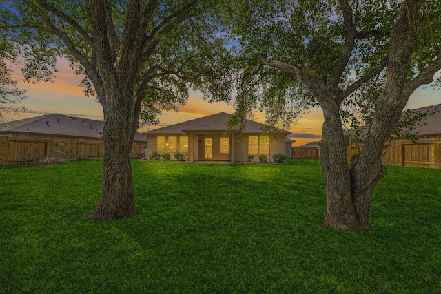 back house at dusk with a yard