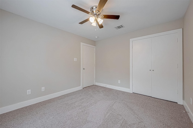 unfurnished bedroom with light carpet, ceiling fan, and a closet