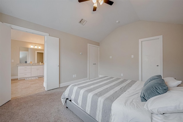 bedroom with lofted ceiling, ensuite bath, light carpet, and ceiling fan