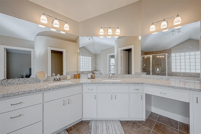 bathroom featuring lofted ceiling, vanity, and walk in shower