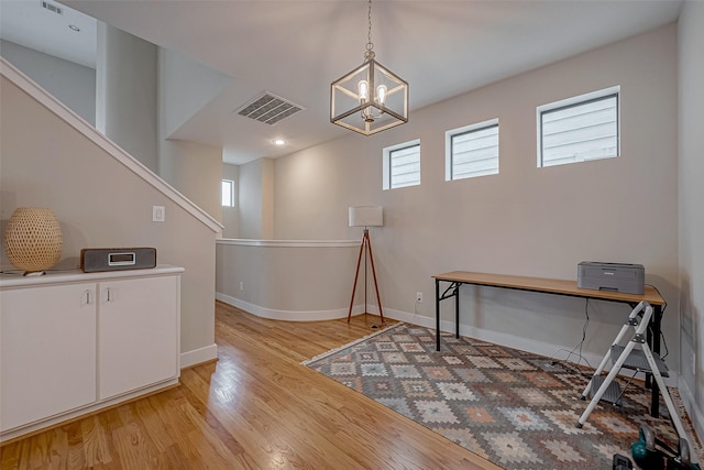 office space with a notable chandelier and light wood-type flooring