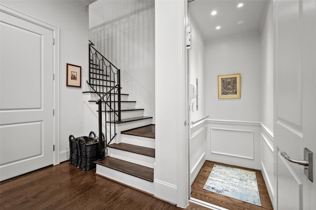 staircase featuring hardwood / wood-style flooring and ornamental molding