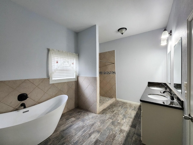 bathroom with vanity, shower with separate bathtub, hardwood / wood-style floors, and tile walls