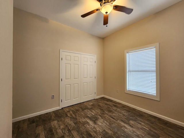 unfurnished bedroom featuring dark wood-type flooring, a closet, and ceiling fan