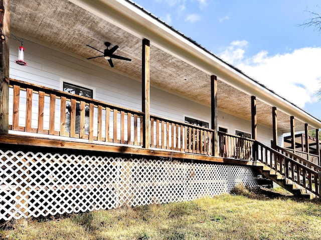 view of side of home featuring ceiling fan and a deck