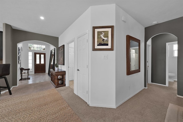 foyer with a wealth of natural light and light colored carpet