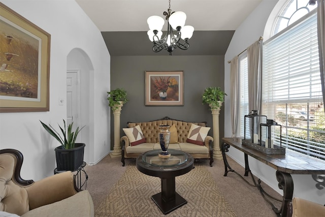 carpeted living room featuring an inviting chandelier and vaulted ceiling