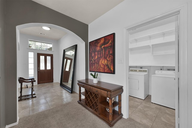 foyer featuring light tile patterned floors and washing machine and clothes dryer