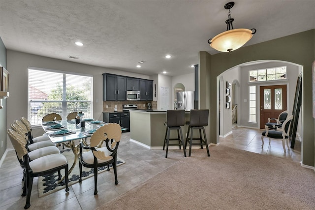 tiled dining area featuring a textured ceiling