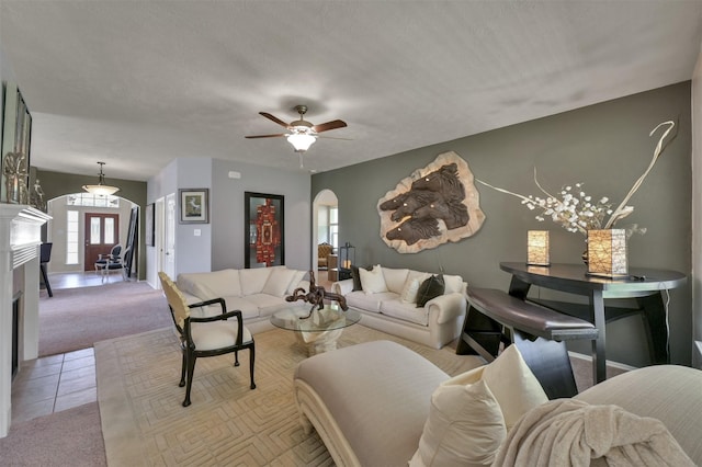 carpeted living room featuring a textured ceiling and ceiling fan