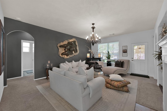 carpeted living room featuring an inviting chandelier