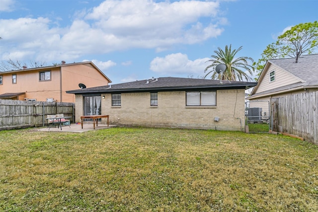 rear view of property featuring central AC unit, a patio area, and a lawn