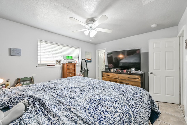 tiled bedroom featuring ceiling fan and a textured ceiling