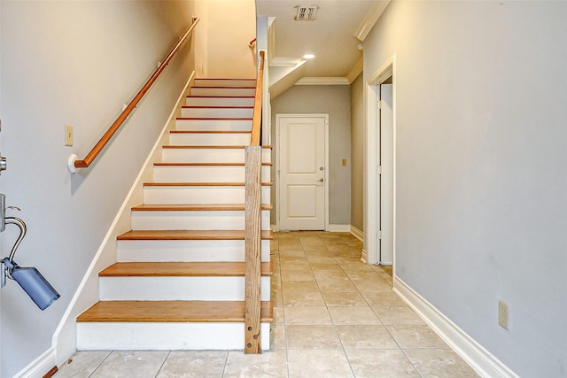 stairs with crown molding and tile patterned floors