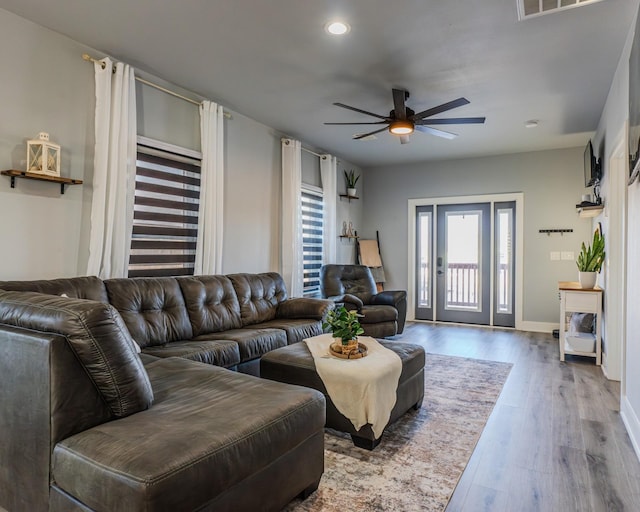 living room with ceiling fan, wood-type flooring, and plenty of natural light