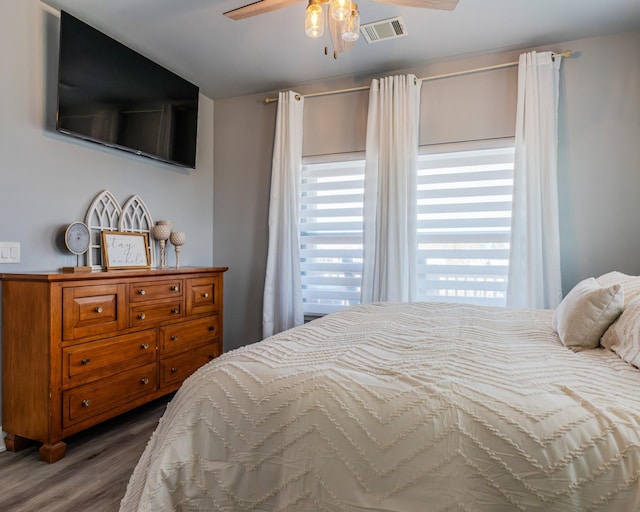 bedroom with dark wood-type flooring, ceiling fan, and multiple windows