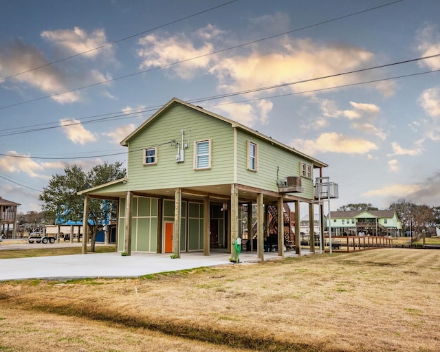 back of property featuring a yard and central AC