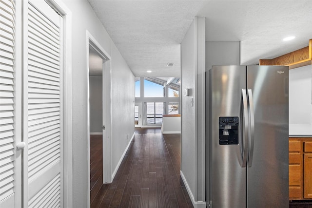 hallway with dark hardwood / wood-style floors and a textured ceiling