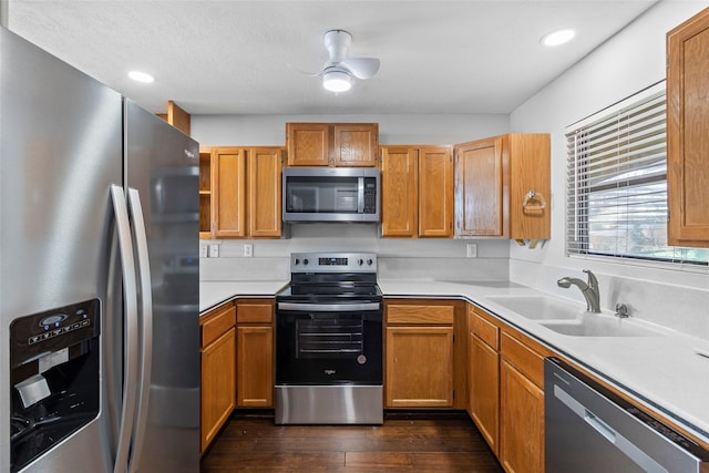 kitchen with dark hardwood / wood-style flooring, sink, ceiling fan, and appliances with stainless steel finishes