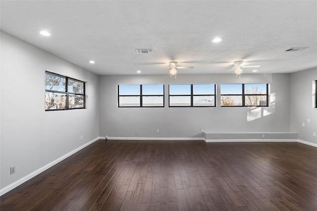 unfurnished room with ceiling fan, dark hardwood / wood-style floors, and a textured ceiling