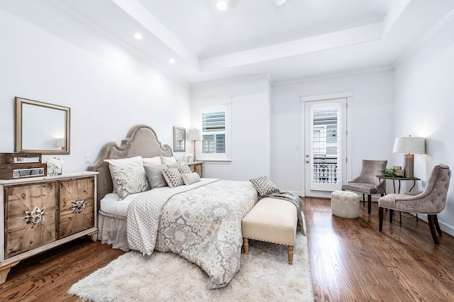 bedroom featuring dark hardwood / wood-style floors, access to outside, and a tray ceiling