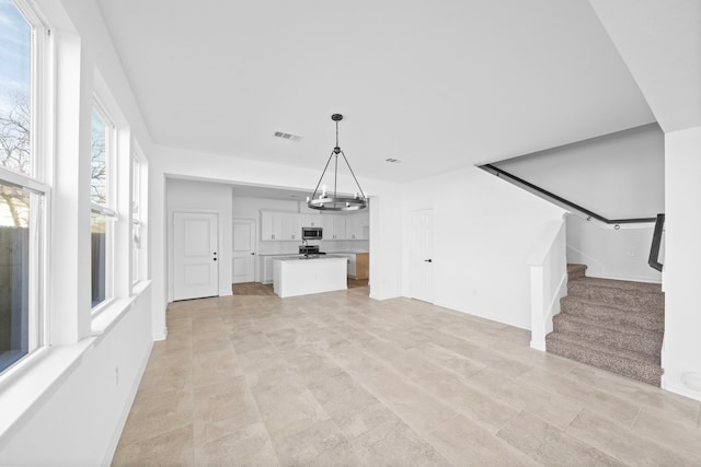 unfurnished living room featuring a chandelier