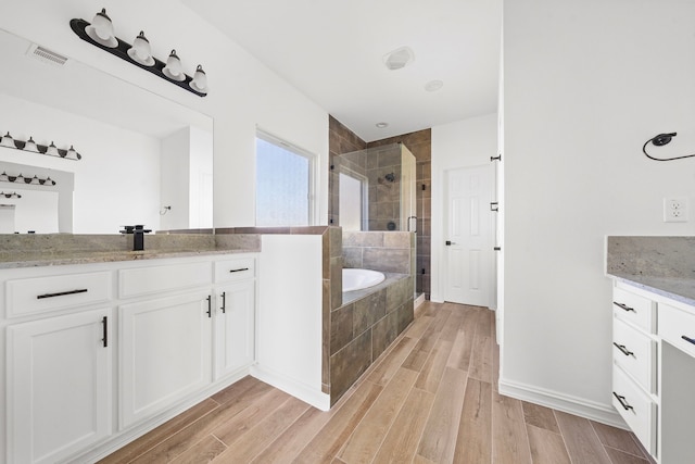 bathroom with vanity and shower with separate bathtub