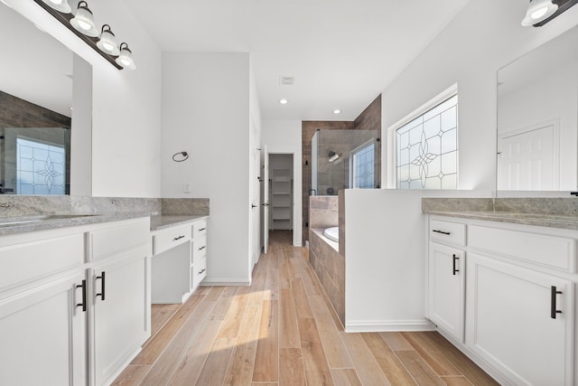 bathroom with hardwood / wood-style flooring, vanity, and separate shower and tub