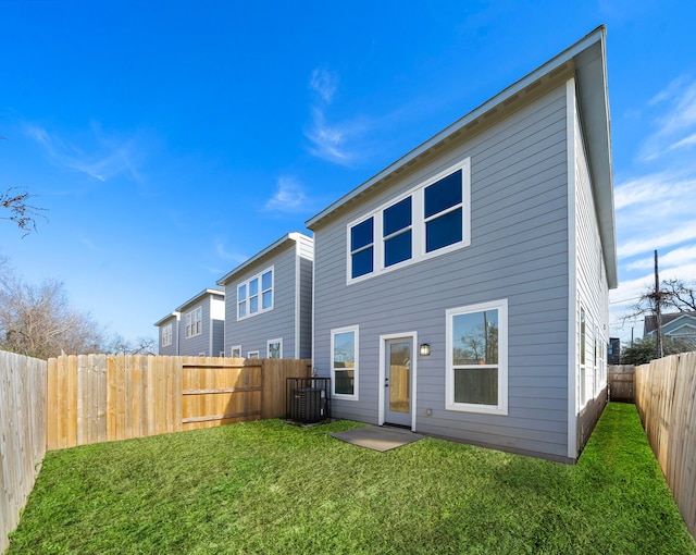 back of property featuring central AC unit and a yard