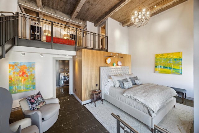 tiled bedroom with beam ceiling, a towering ceiling, a notable chandelier, washer / dryer, and wooden ceiling