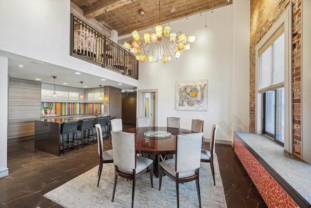 dining area featuring a towering ceiling, a chandelier, and wooden ceiling