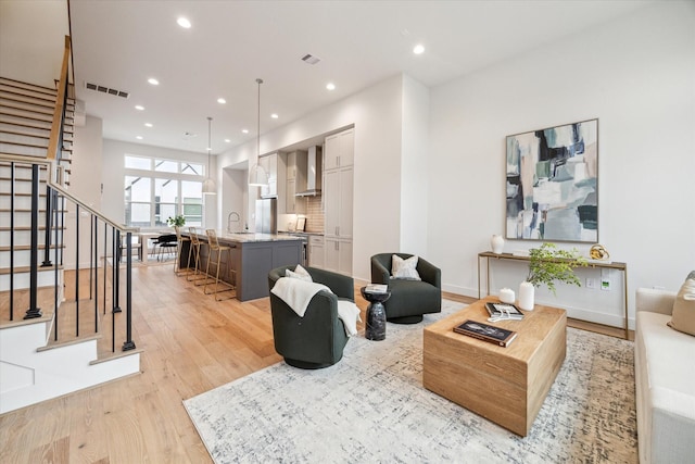 living room featuring sink and light hardwood / wood-style flooring