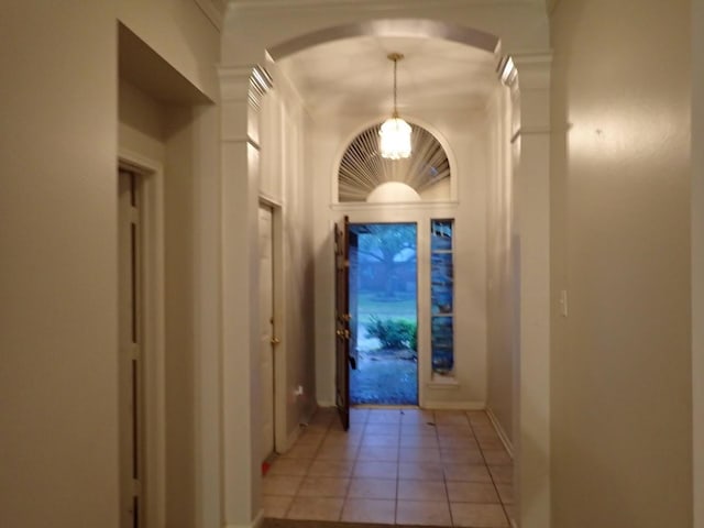 doorway featuring ornate columns and light tile patterned flooring