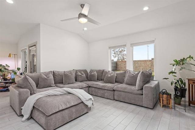 living room featuring ceiling fan, vaulted ceiling, and light hardwood / wood-style flooring